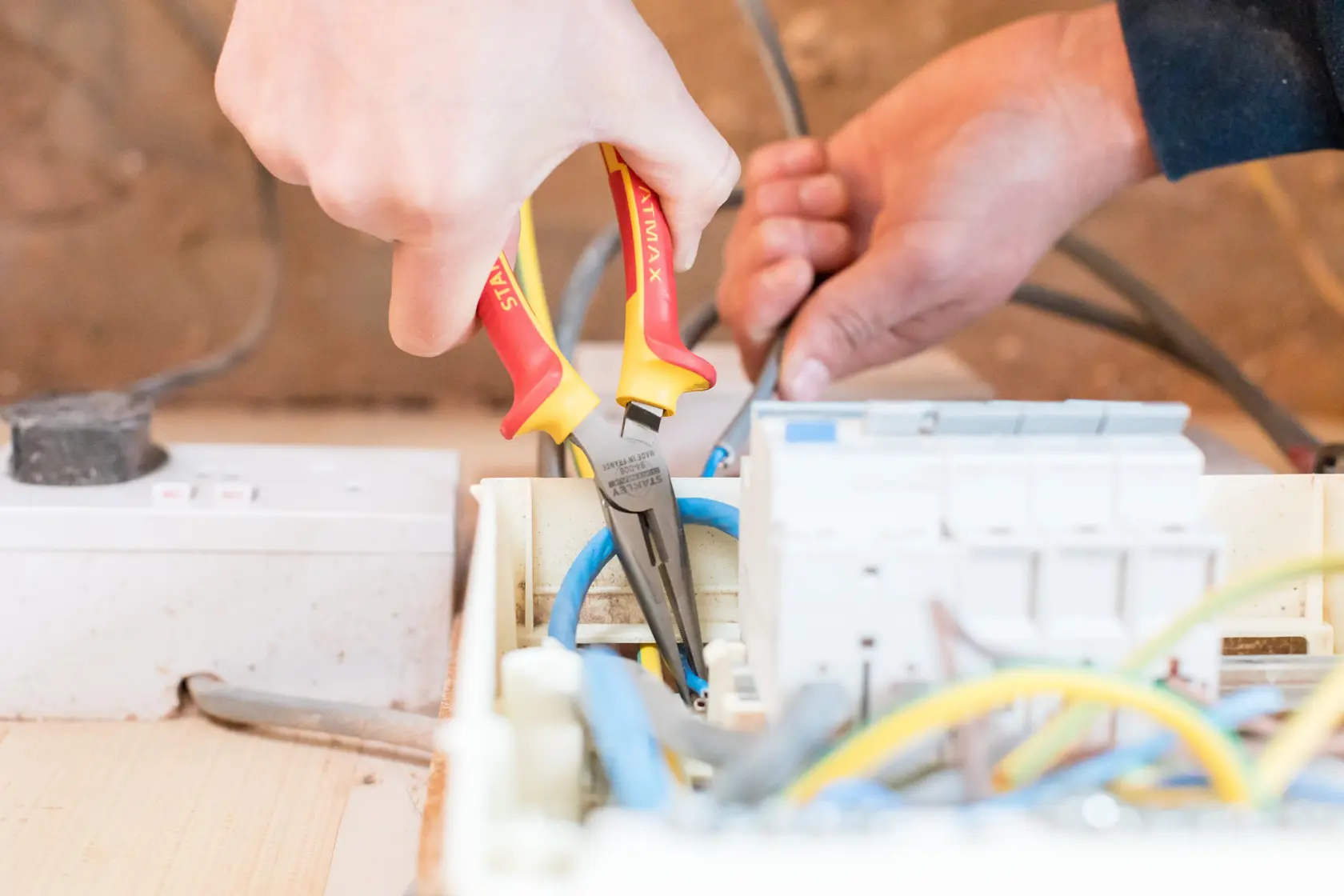 Photo of STANLEY 0-84-006 insulated pliers being used on electrical wiring in a control panel.