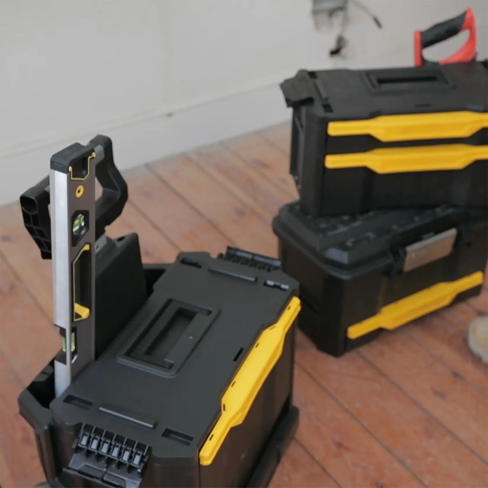 STANLEY 1-79-206 stackable black and yellow toolboxes with level tool, front angle, on wooden floor
