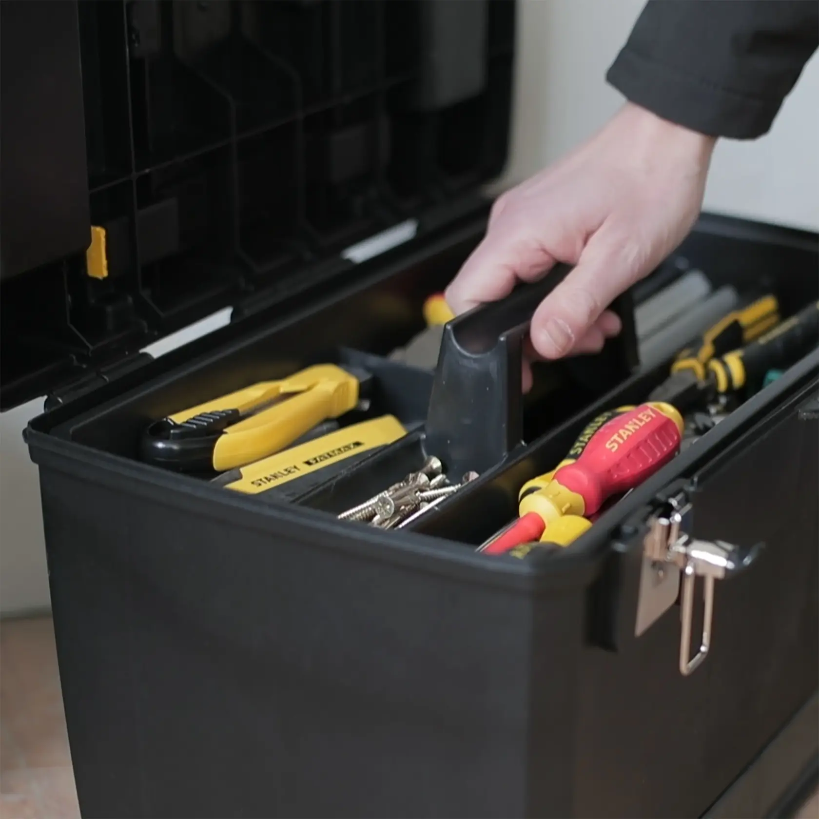 STANLEY 1-93-968 toolbox photography showing organized tools and screws with a hand lifting the tray.