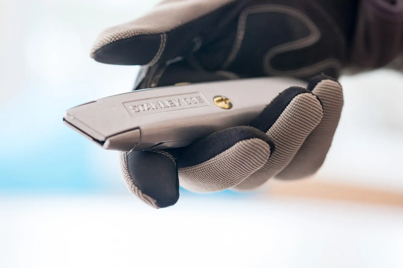 STANLEY 2-10-099 utility knife held in gloved hand, close-up view.