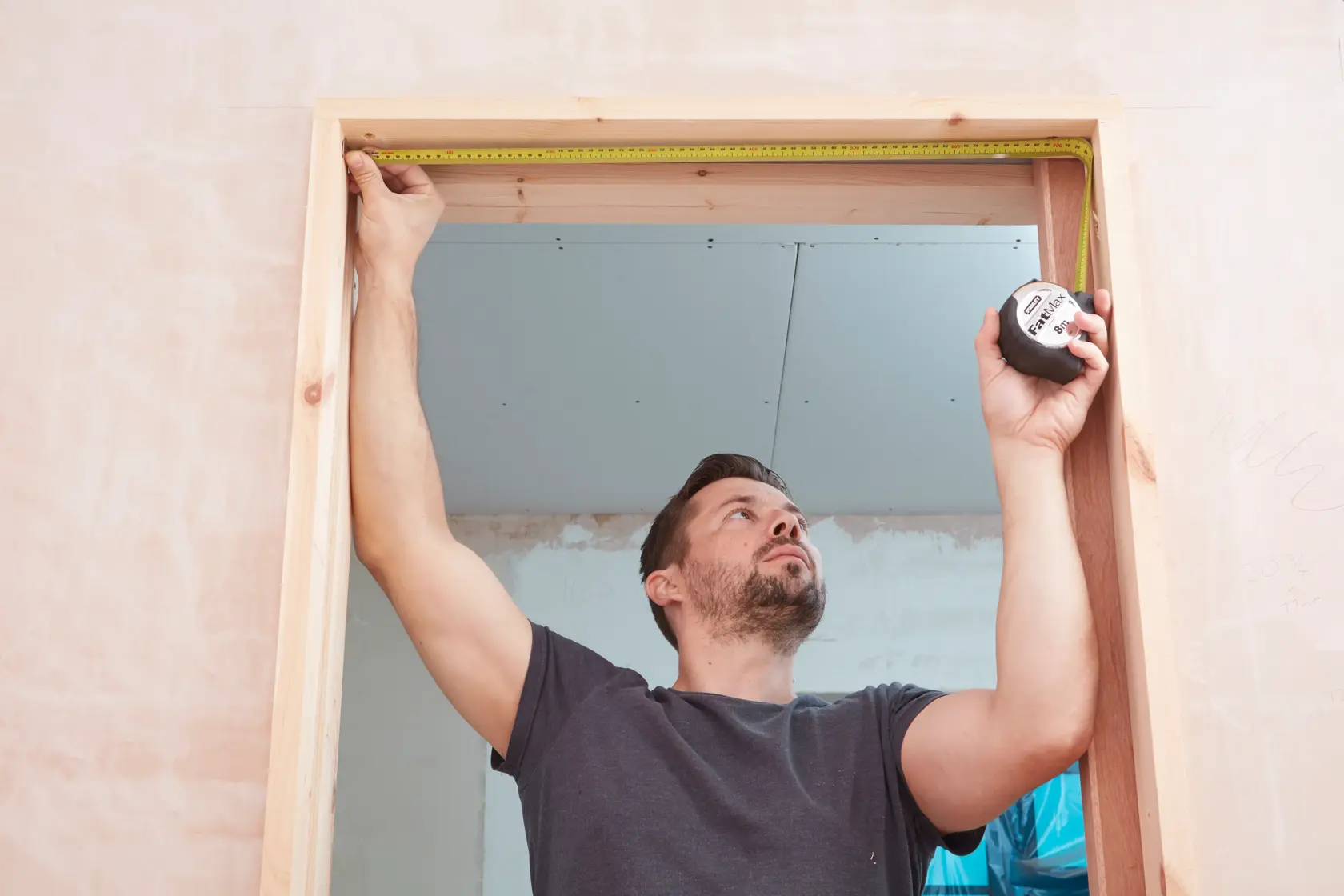 STANLEY 33-894 tape measure being used to measure a wooden door frame, front angle.