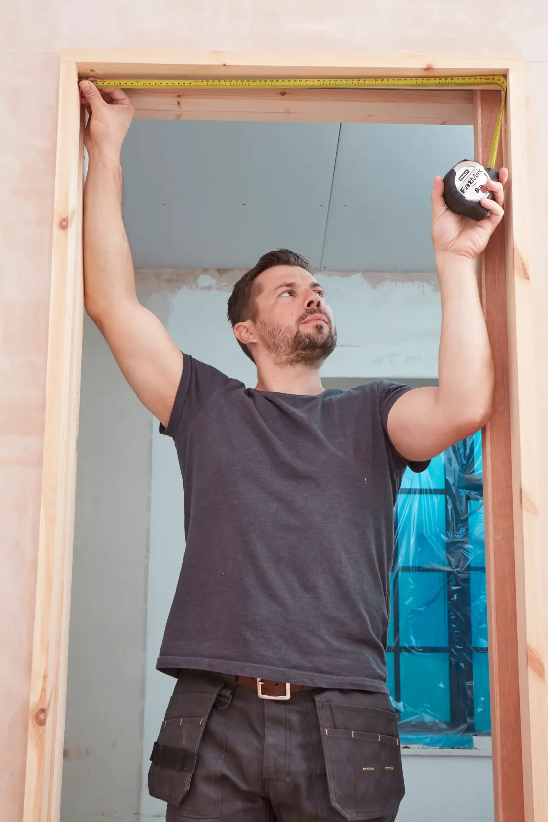 STANLEY 33-894 tape measure used to measure a wooden door frame in an indoor setting.