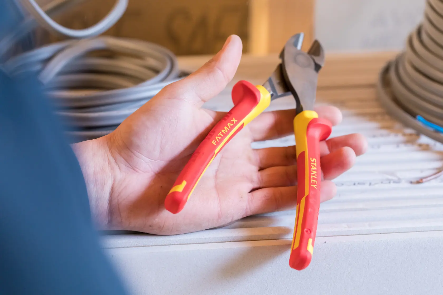 STANLEY 84-004-S insulated wire cutter with red and yellow FATMAX grips, held in hand, photography.