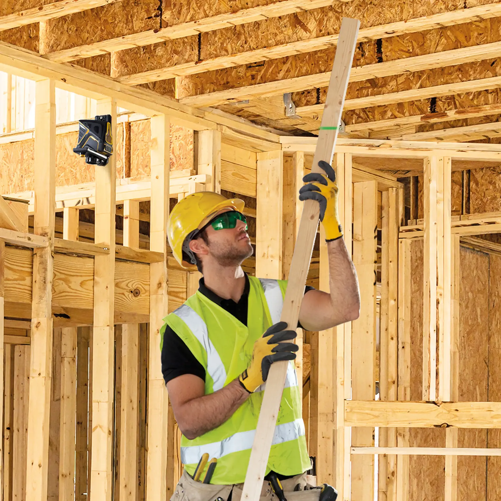 STANLEY FMHT1-77348 laser level mounted on wooden framing, construction site background.