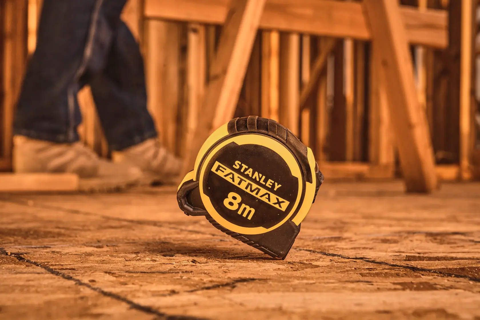 STANLEY FMHT33103-3 tape measure, FATMAX, 8m, black and yellow, on construction site floor.