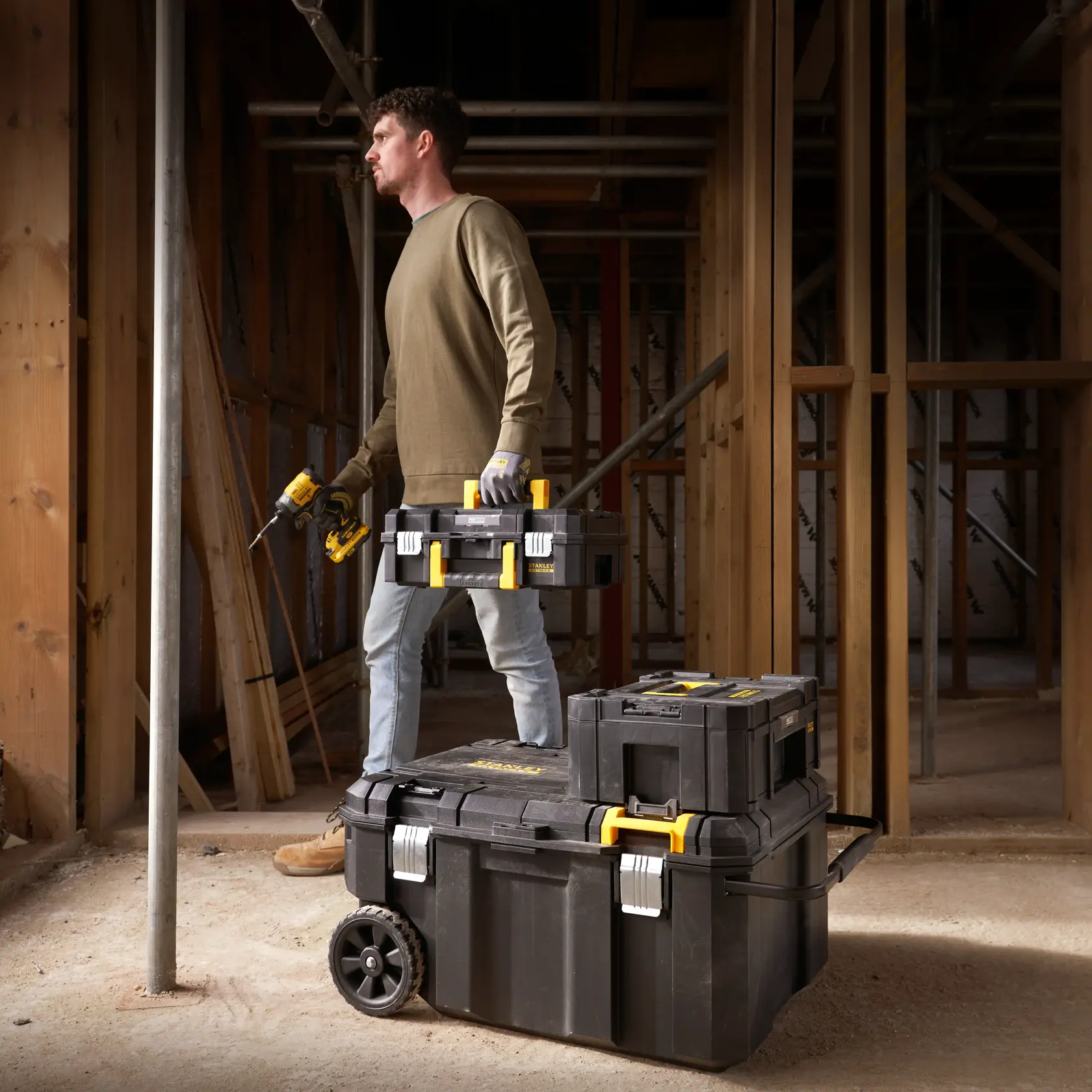 STANLEY FMST17870-1 modular toolboxes stacked on wheels, carried at construction site.