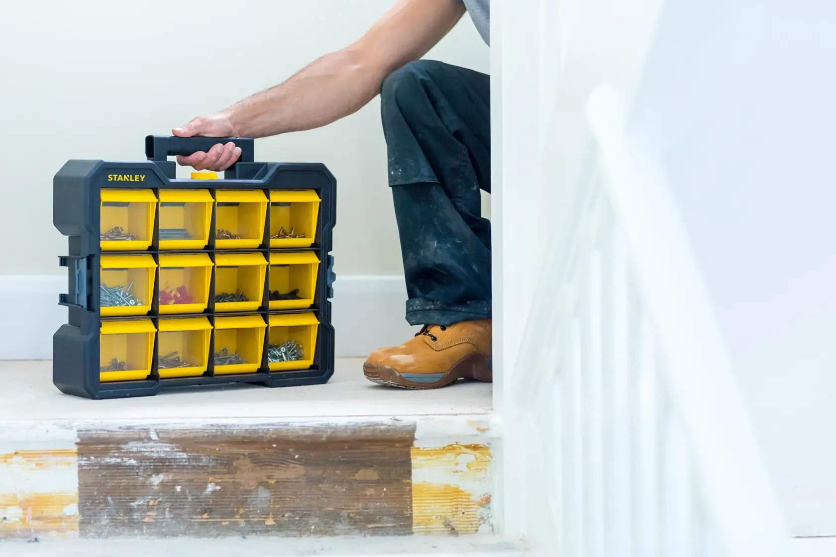 Photo of STANLEY FMST81077-1 organizer case with yellow compartments, carried by person on stairs.