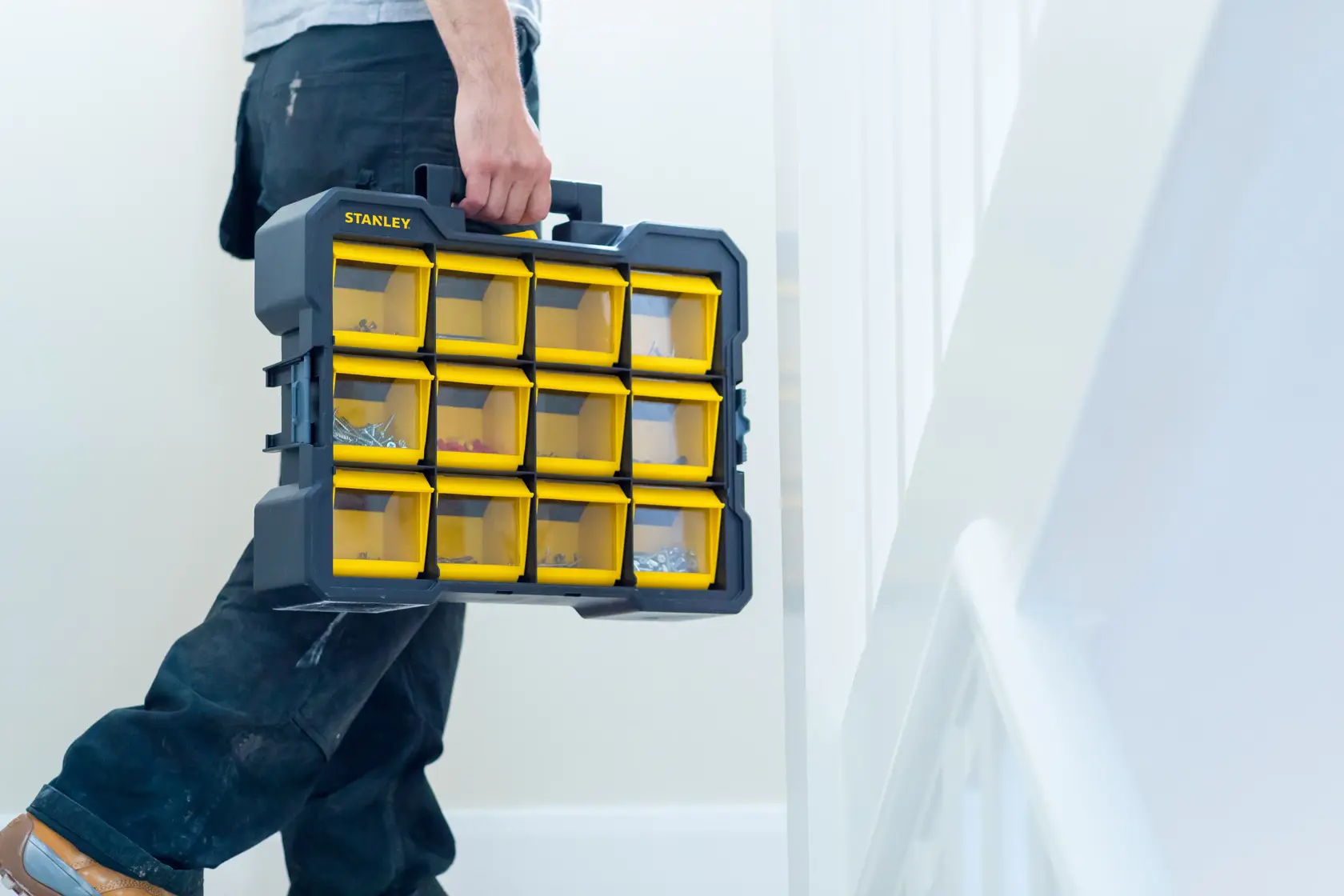 STANLEY FMST81077-1 organizer with yellow transparent bins, carried by hand indoors.