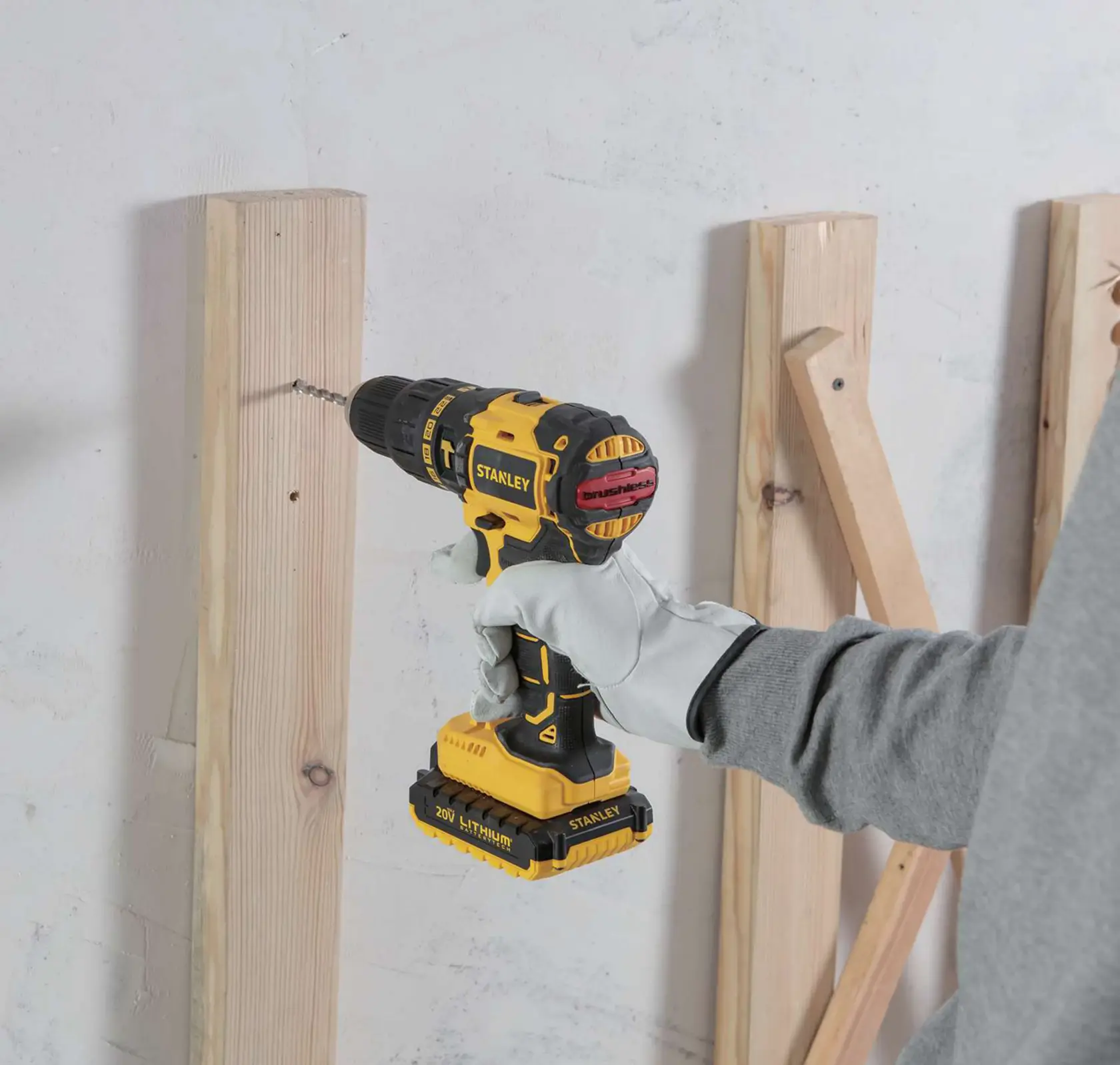 STANLEY SBH20S2K cordless drill being used to drill into wood, close-up side view.