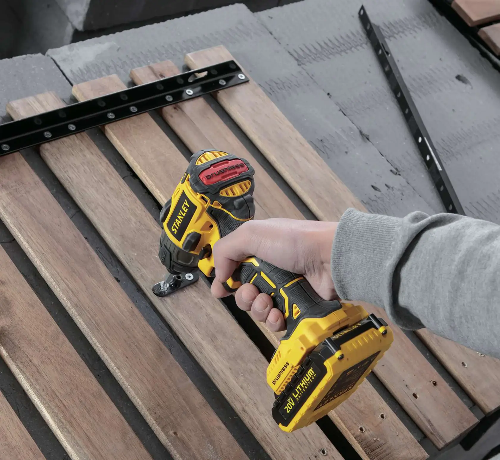 Photo of STANLEY SBI20S2K cordless impact driver in use, driving screw into wooden boards.