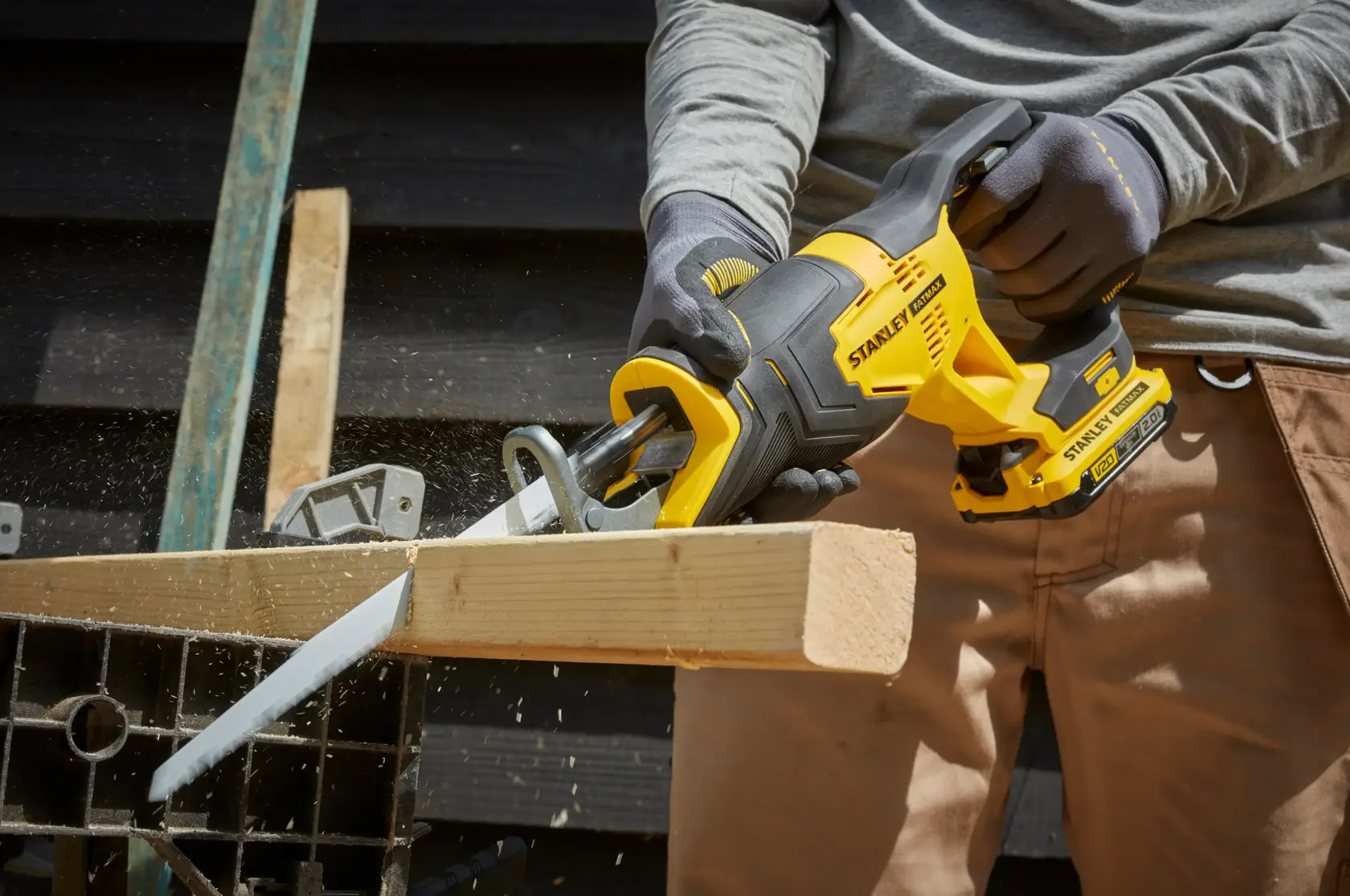 STANLEY SFMCS300D1K cordless reciprocating saw cutting wood, close-up outdoor photography.