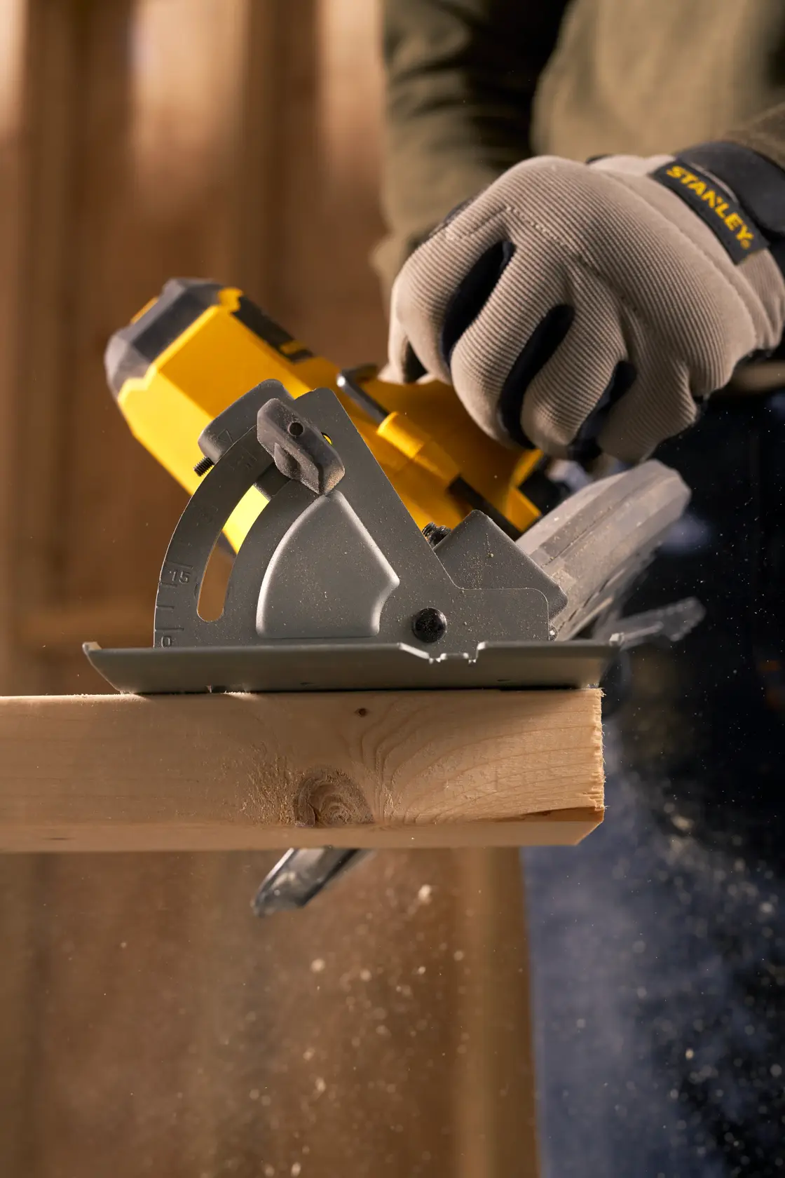 STANLEY SFMCS500D1K cordless circular saw cutting wood, worker wearing STANLEY gloves, close-up action.