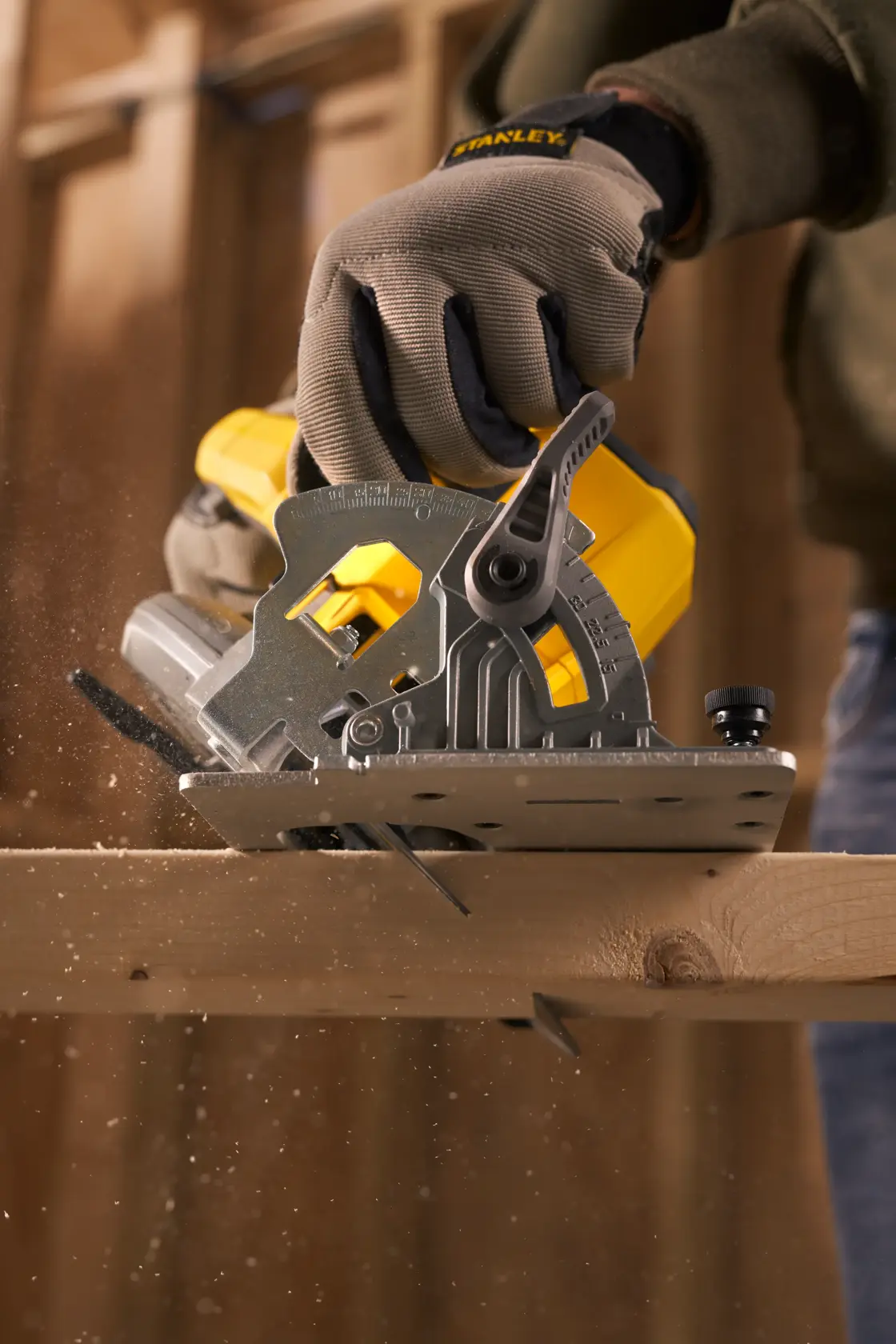 Photo of STANLEY SFMCS500D1K circular saw cutting wood, gloved hand holding saw, woodworking in progress.