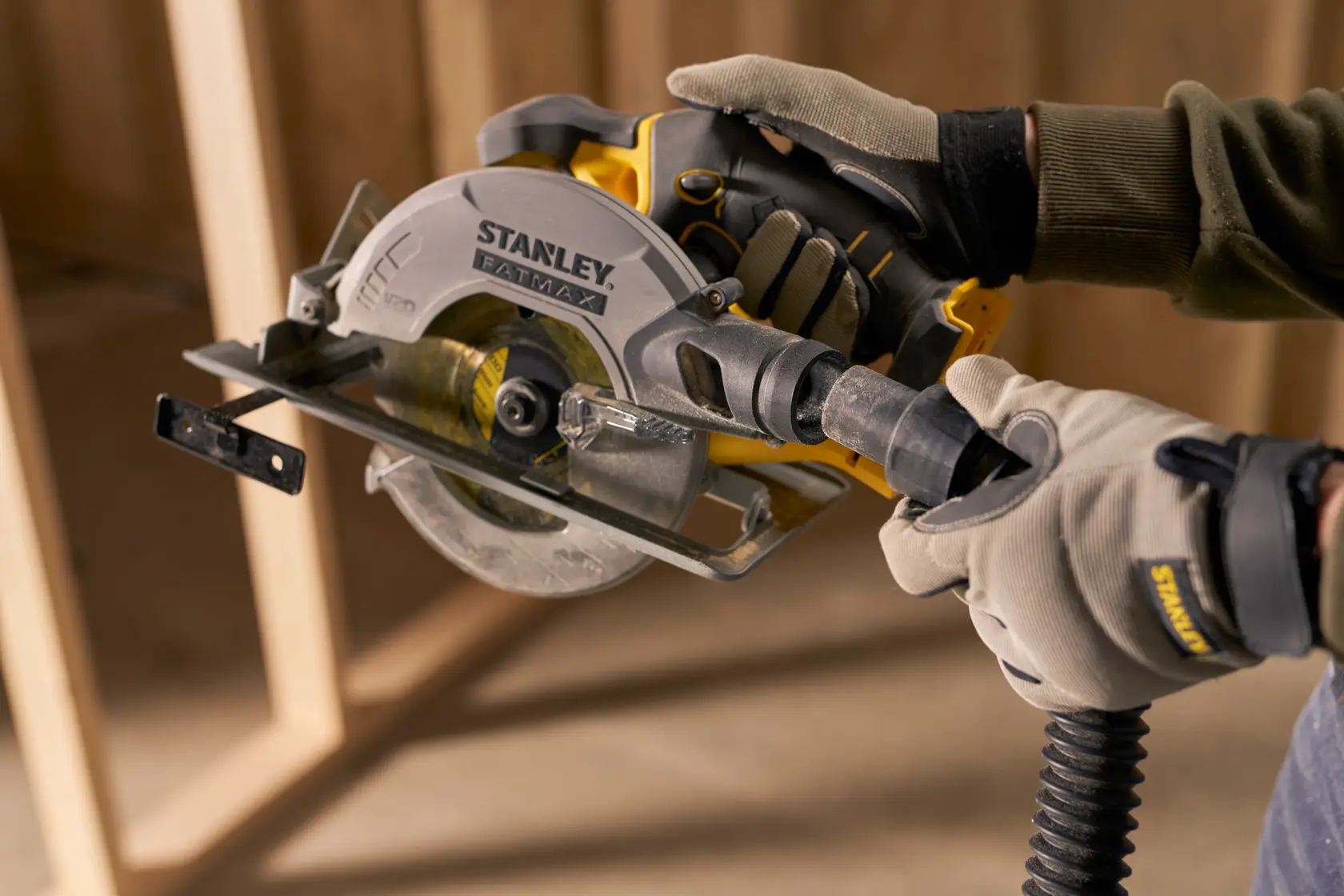 STANLEY SFMCS500D1K circular saw held by gloved hands in workshop setting.