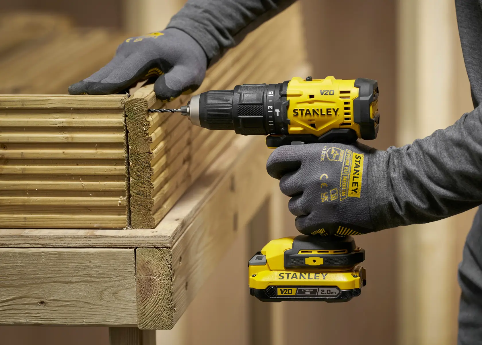 Stanley drill used on wood, STA56001-QZ and STA56001 SKUs shown, person wearing gloves.