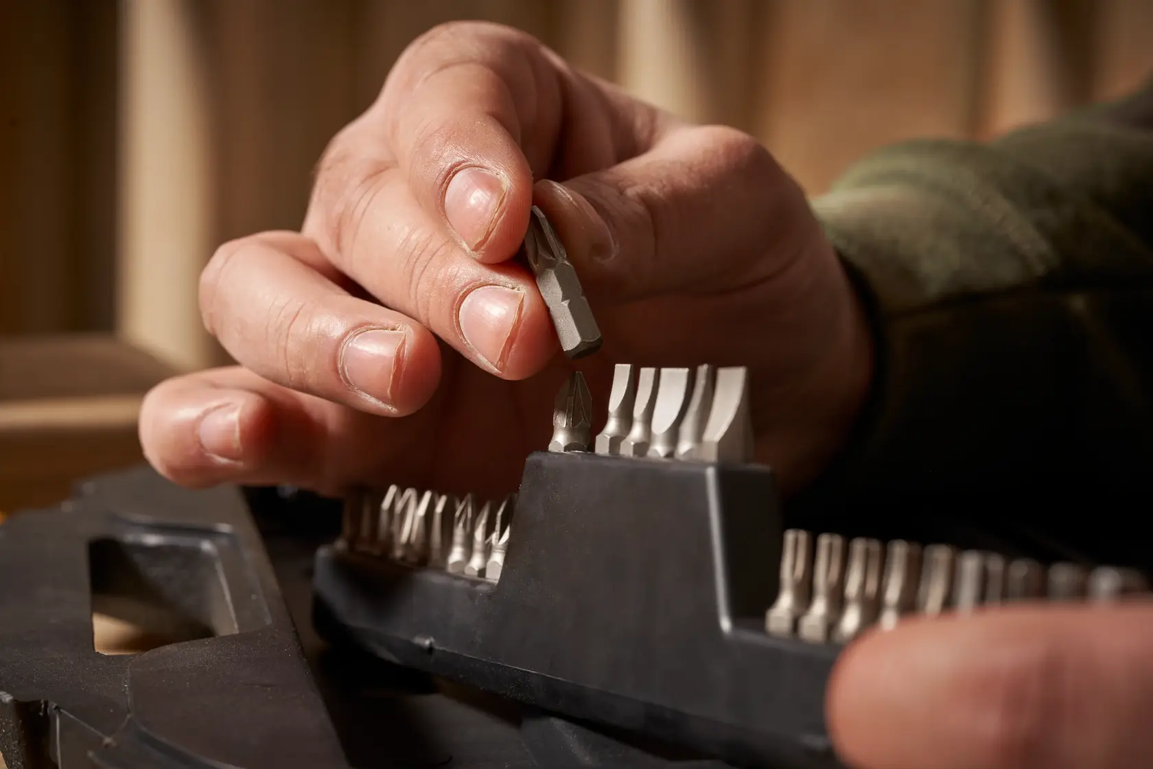 STANLEY STA7184 screwdriver bit set, close-up of hand picking a bit from plastic holder.