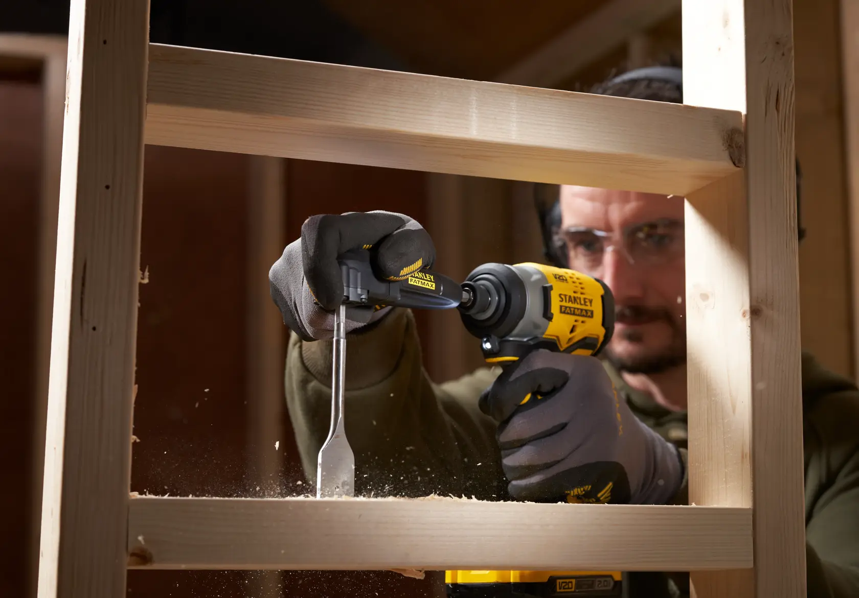 Photo of STANLEY STA88582-XJ angle drill attachment used in woodworking, shown drilling into wood frame.