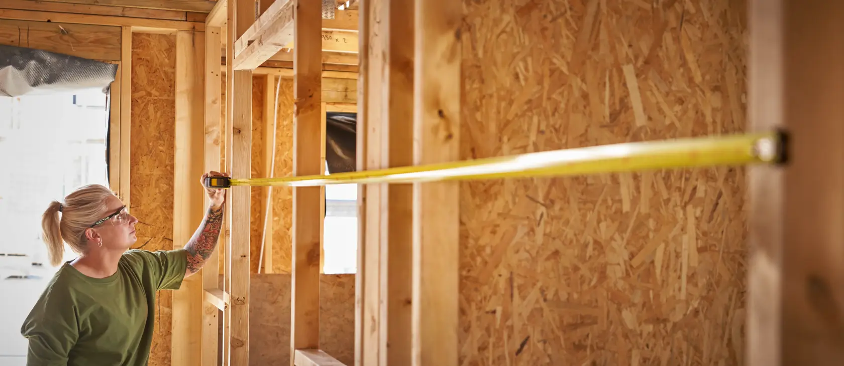 STANLEY STHT37233-0 tape measure in use at construction site, extended across wooden framing.