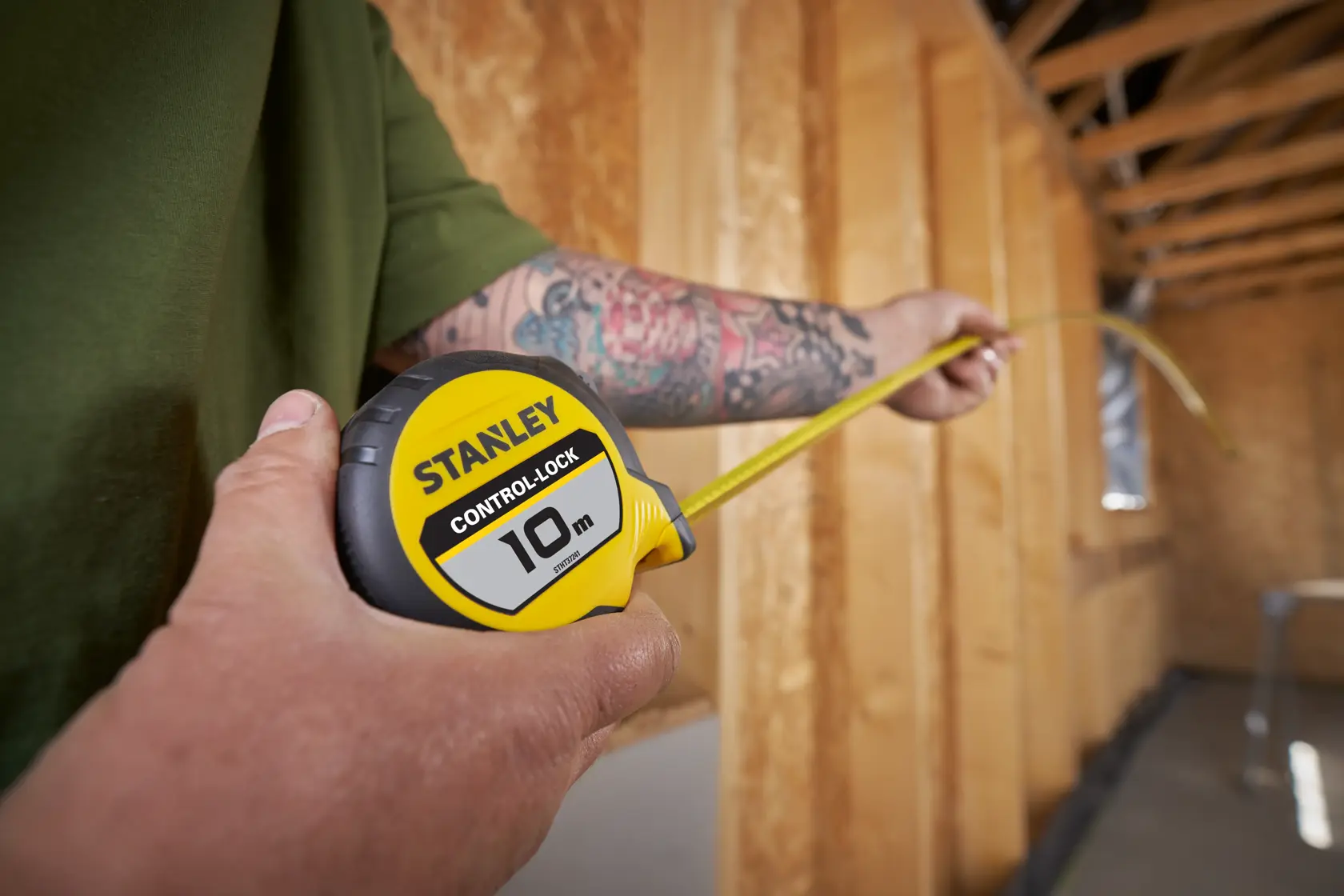Stanley Control Lock 10m tape measure being used in a wooden construction setting.