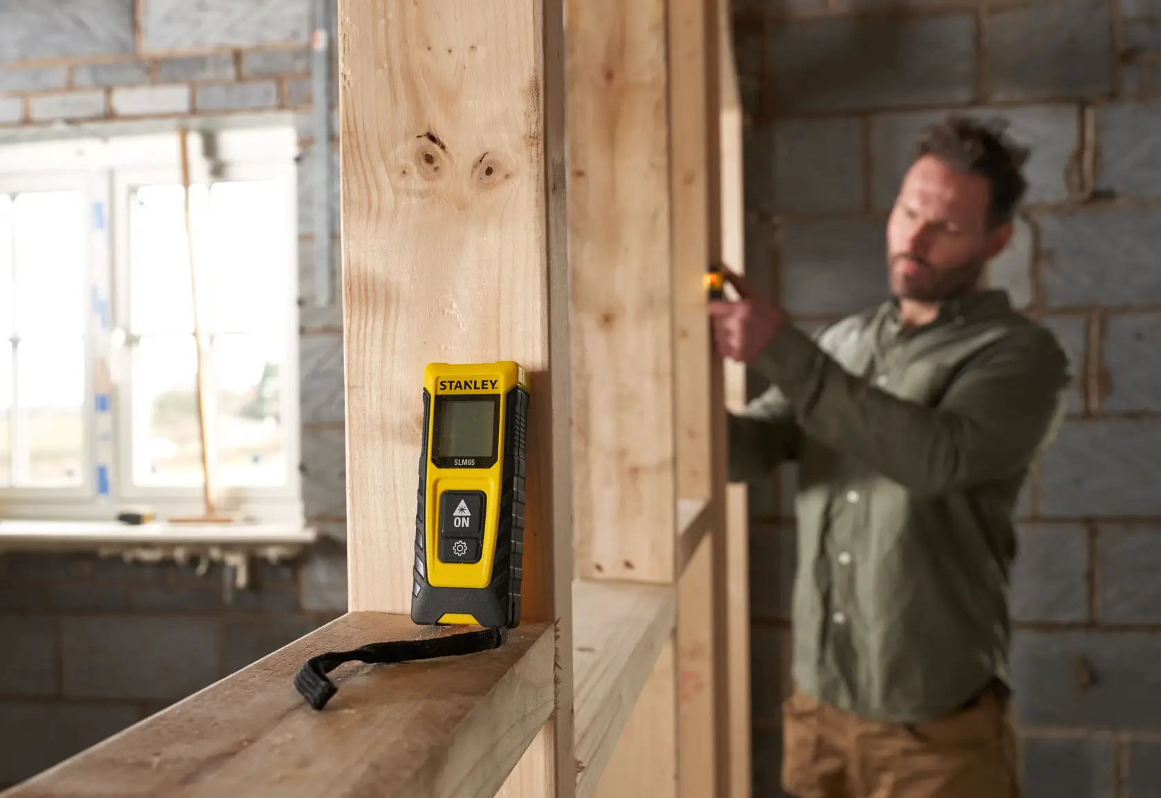 STANLEY STHT77065-0 laser distance measurer photography in construction setting.