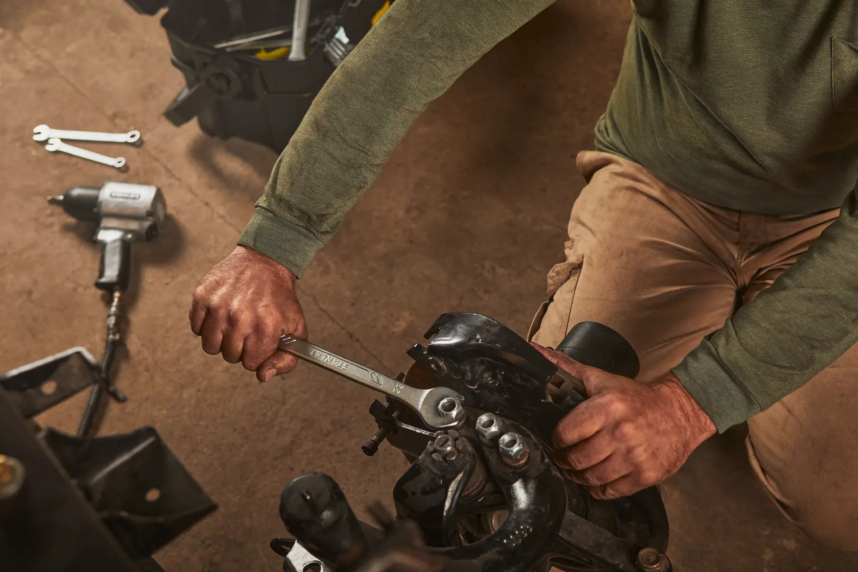 Photo of STANLEY STMT72819 wrench in use on machinery, with tools and toolbox nearby, product category: photography.