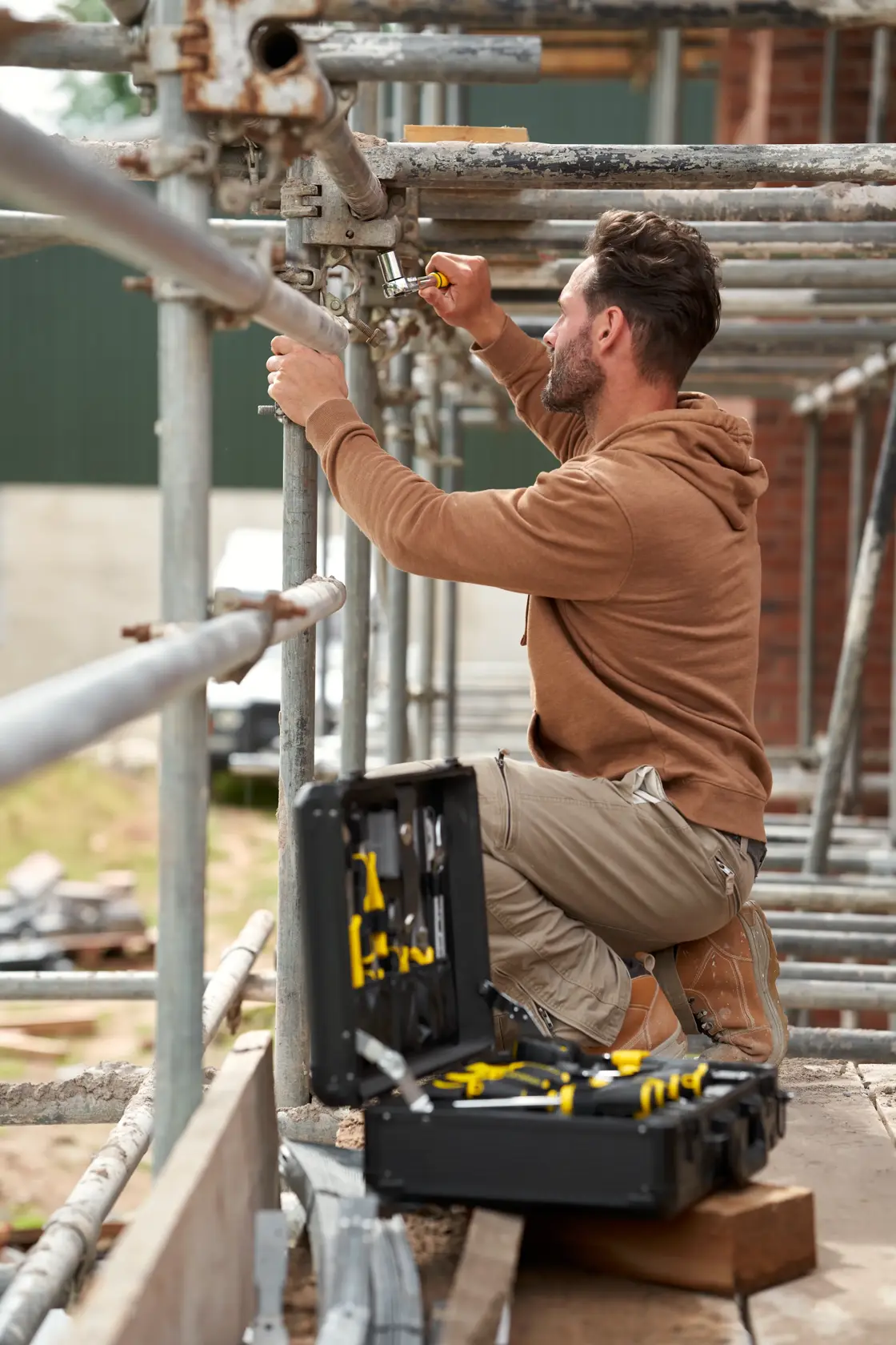 STANLEY STMT98109-1 maintenance suitcase 142PCS open on scaffolding with worker using tools outdoors.