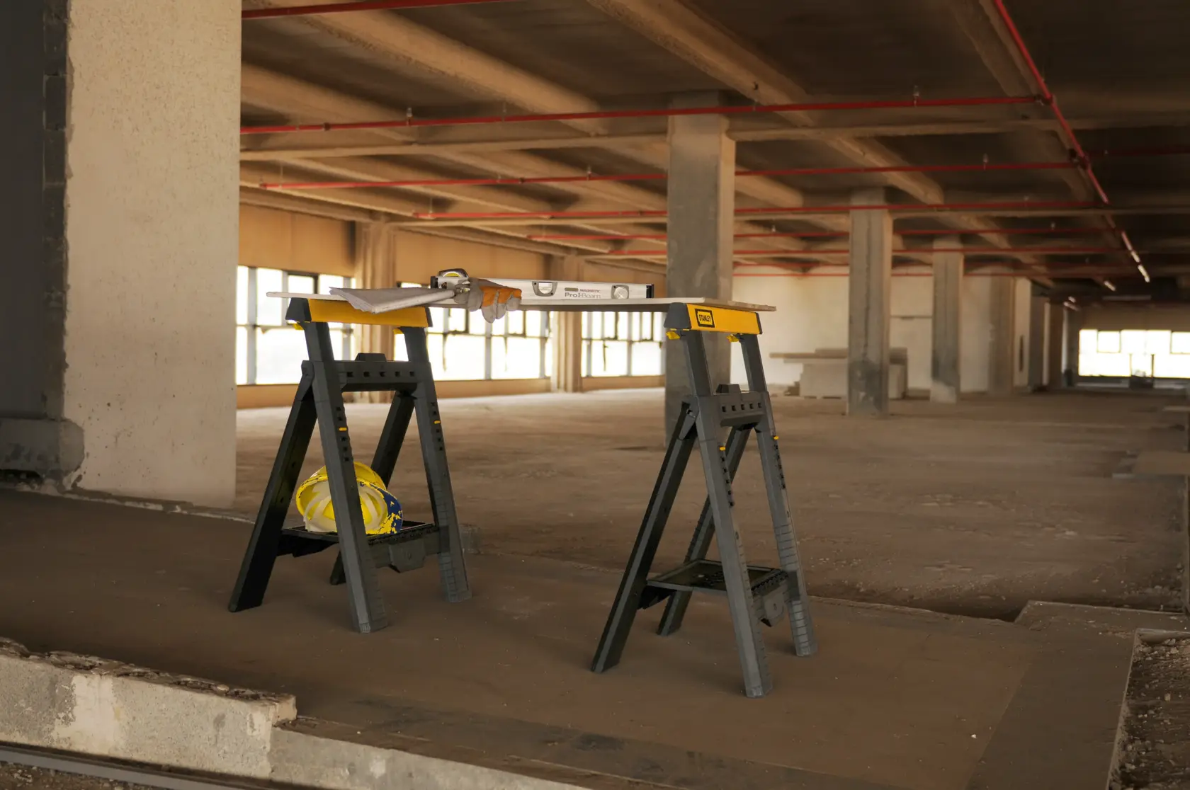 STANLEY STST1-70559 folding sawhorses with tools on top, photographed in a construction site.
