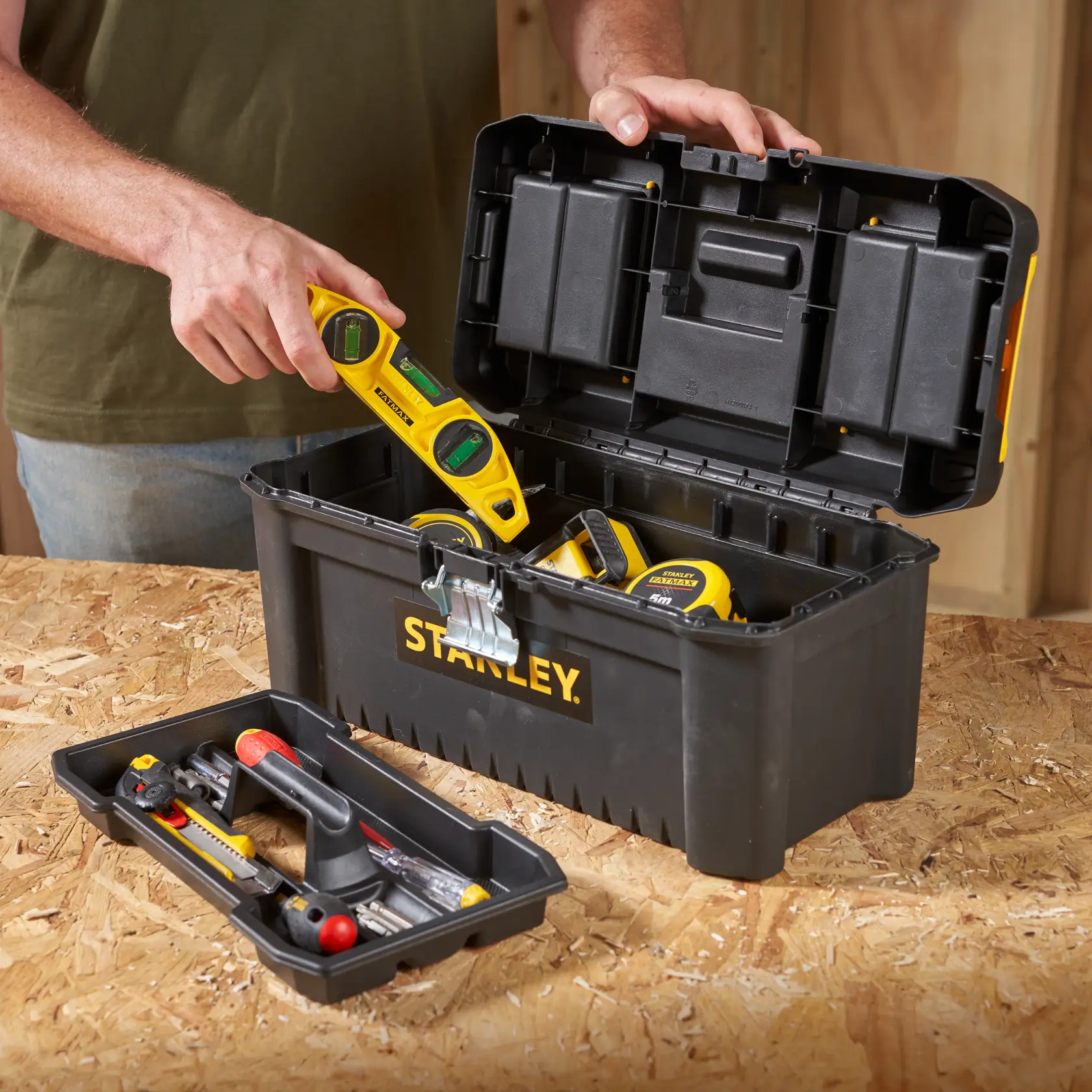STANLEY STST1-75518-KR black toolbox with tools, open lid, photographed on a workbench.