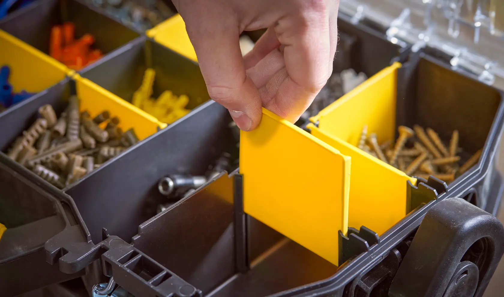 STANLEY STST1-79231 organiser case showing hand adjusting yellow divider, assorted screws inside compartments.